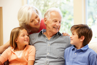 Grandparents laughing with their two grandchildren at home