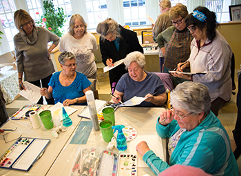 Alice Broadbent, center, demonstrates masking, an
advanced technique in watercolor painting.